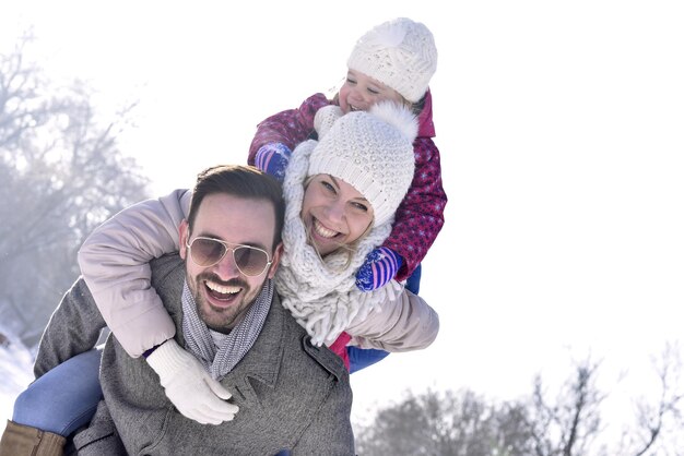 Shallow focus shot of a beautiful family having fun during a snowy weather