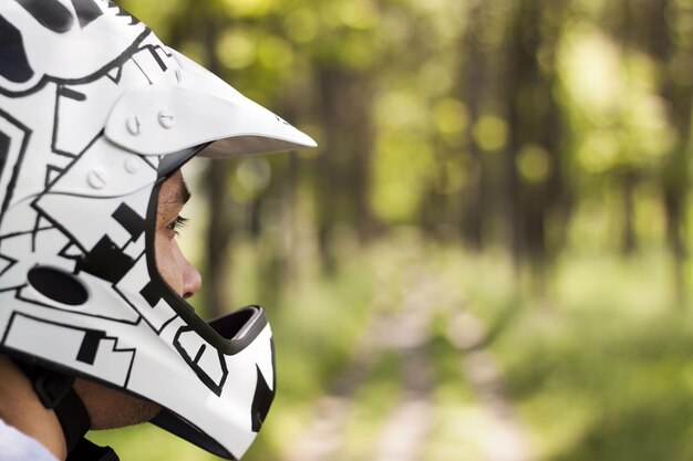 Shallow focus shot of a caucasian male wearing a cool patterned motorcycle helmet outdoors