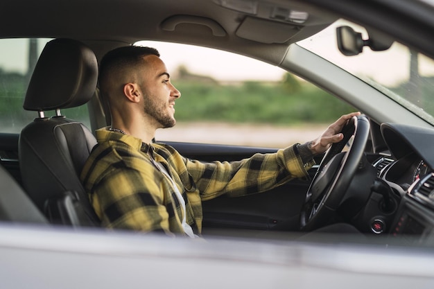 Free photo shallow focus shot of a handsome spanish caucasian man sitting behind the wheel of a modern car