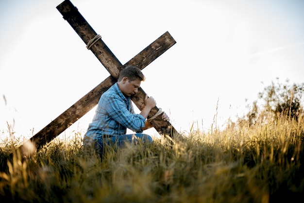 Free photo shallow focus shot of a male carrying a handmade cross