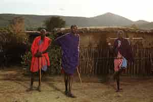 Бесплатное фото Неглубокий снимок трех африканских мужчин, держащих палки