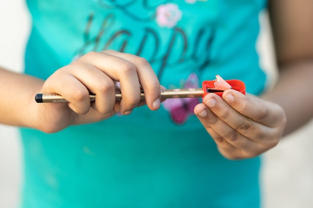 Shallow focus shot of a person sharpening a pencil