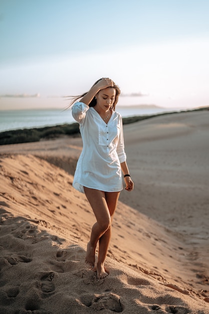 Shallow focus shot of a pretty girl in white on the bea