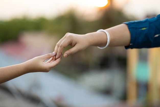 Shallow focus shot of two hands touching each other gently