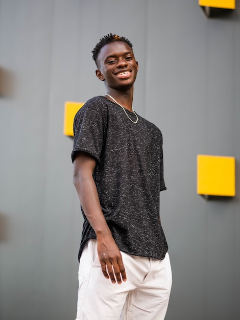 Free photo shallow focus shot of a young black male on a grey wall