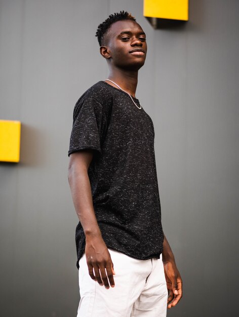 Shallow focus shot of a young black male on a grey wall