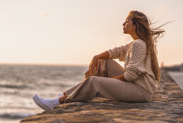 ウールのカーディガンで若いブロンドの女性の浅いフォーカスショット