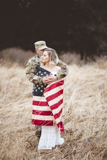 妻を抱き締めるアメリカ兵の浅い焦点の垂直ショット