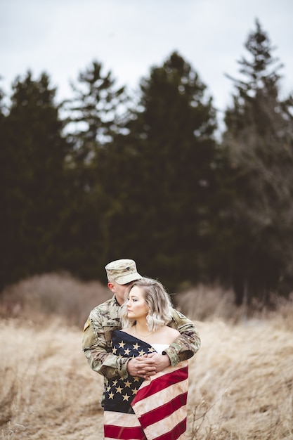 Free photo shallow focus vertical shot of an american soldier hugging his wife