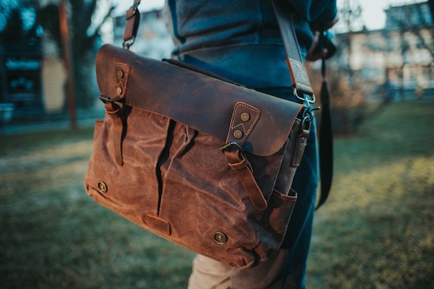 Shallow focus view of a male wearing a brown leather satchel