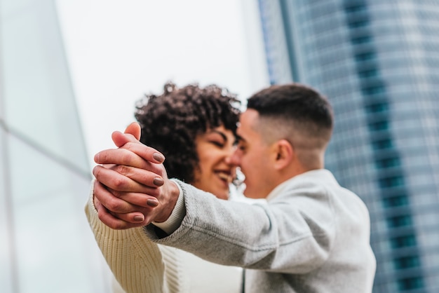 Shallow focus of a young romantic couple dancing and kissing outdoors