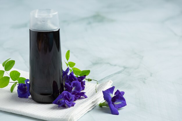 Shampoo bottle of Butterfly Pea Flower put on white marble background