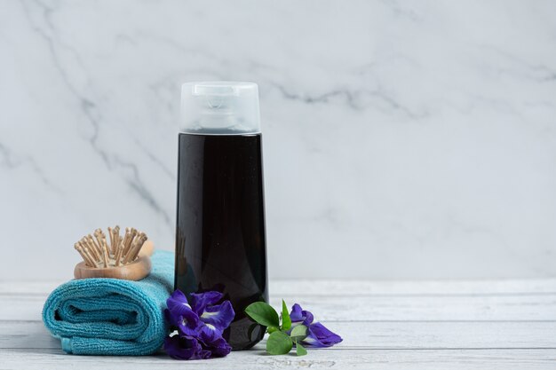 Shampoo bottle of Butterfly Pea Flower put on white wooden background