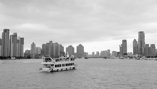 흑백으로 흐린 날에 강 위에 상하이 건축