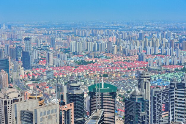 Shanghai city aerial view with urban architecture and blue sky in the day.