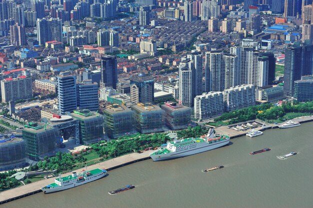 Вид с воздуха города Шанхая с городской архитектурой над рекой и голубым небом в дне.