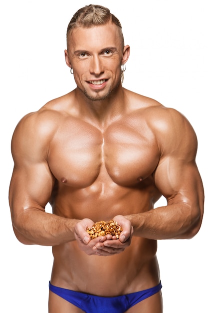 Shaped and healthy body man holding walnuts