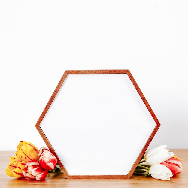 Free photo shaped photo frame with flowers in composition