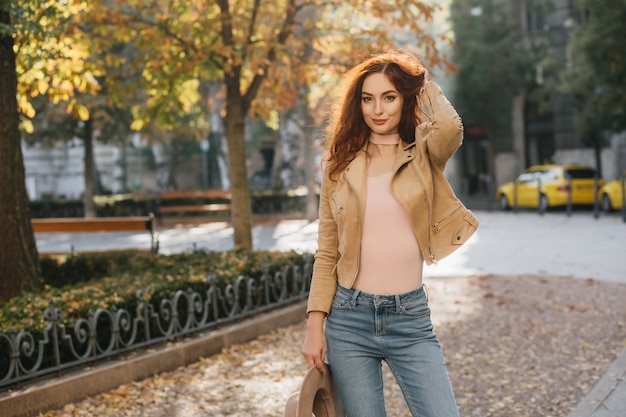 Formosa donna dai capelli scuri in jeans godendo l'autunno