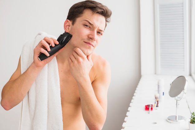 Бесплатное фото Концепция бритья с привлекательным мужчиной