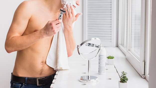 Shaving concept with attractive young man