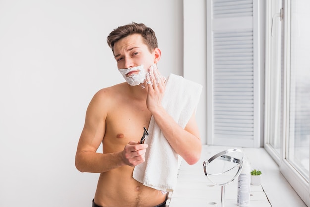 Shaving concept with attractive young man