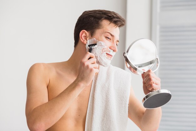 shaving concept with attractive young man