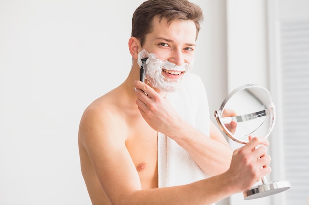 Концепция бритья с привлекательным молодым человеком