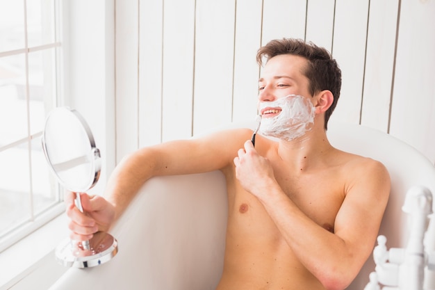 Бесплатное фото Концепция бритья с привлекательным молодым человеком