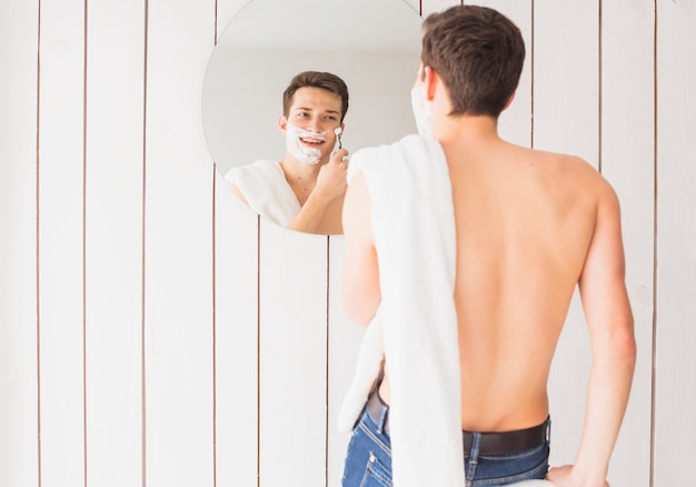 Концепция бритья с привлекательным молодым человеком