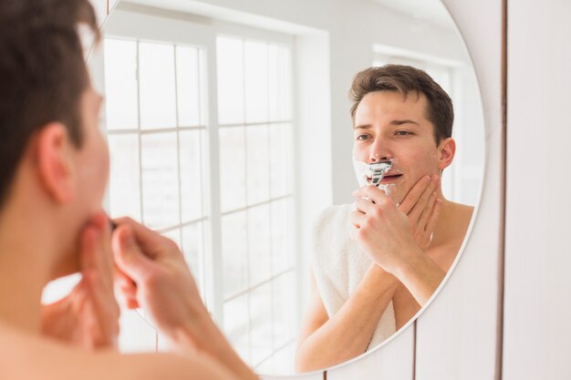 Shaving concept with attractive young man