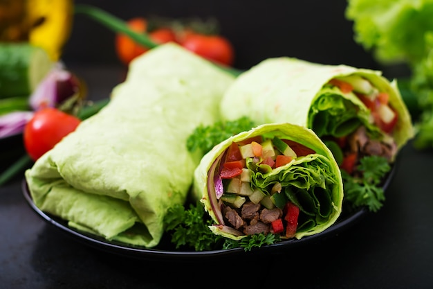 Shawarma from juicy beef, lettuce, tomatoes, cucumbers, paprika and onion in pita bread with spinach. Diet menu