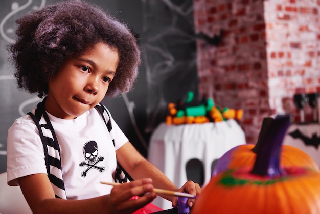 Free photo she clever at painting a pumpkin