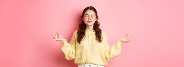 She Is Relaxed Smiling Young Peaceful Girl Meditating Holding Hands In Zen Gesture Close Eyes Feel R