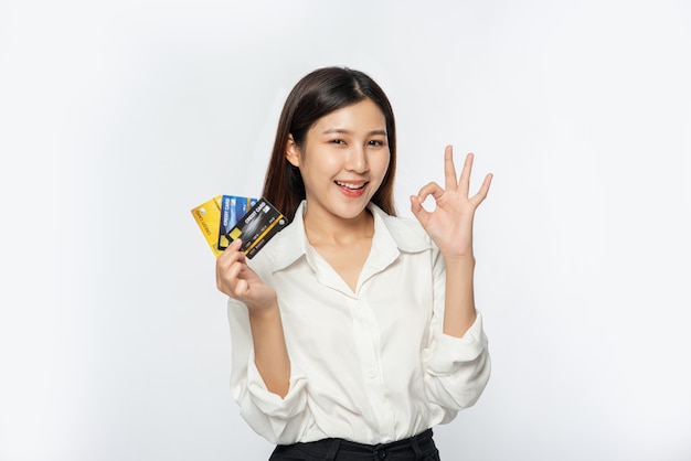 She was dressed in a white shirt and dark pants to go shopping and hold a credit card