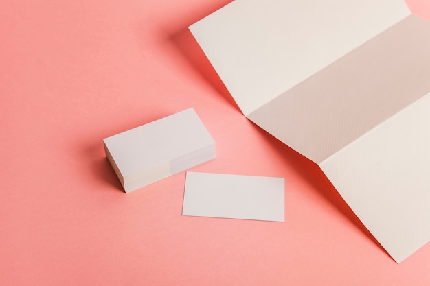 Free photo sheet of folded paper next to stack of business cards