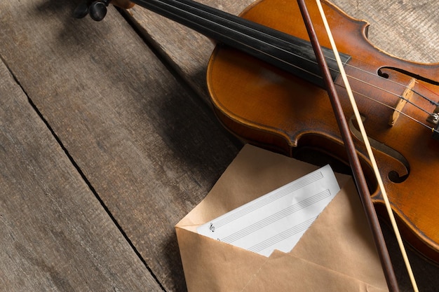 Free photo sheet music and violin on wooden table
