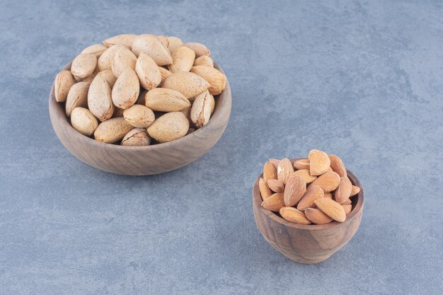 Shelled and unshelled almonds on the marble background. 