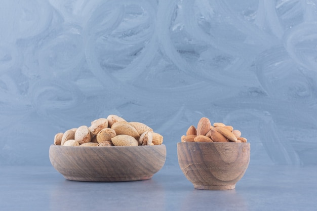 Shelled and unshelled almonds on the marble background. 