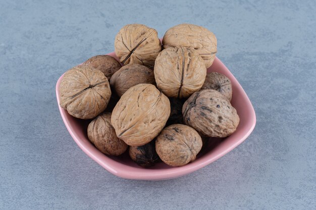 Shelled walnut in the bowl, on the marble table. 