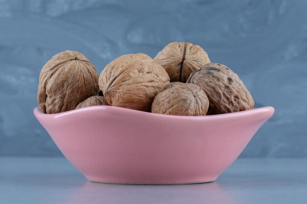 Shelled walnut in the bowl, on the marble table. 