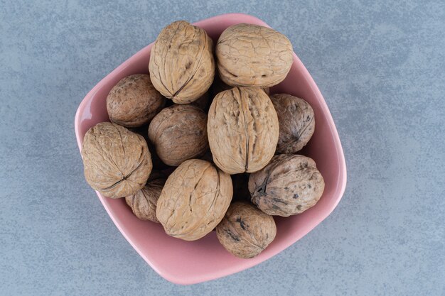 Free photo shelled walnut in the bowl, on the marble table.