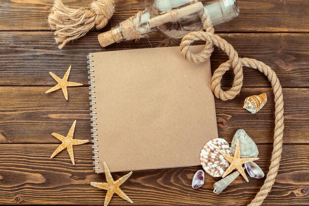 Shells and notepad on wooden table top view with copy space