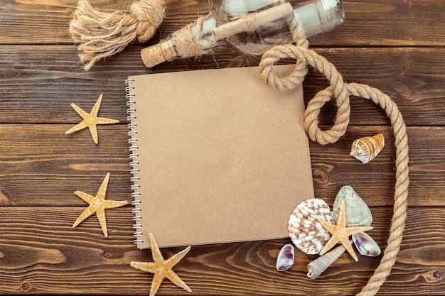 Shells and notepad on wooden table top view with copy space