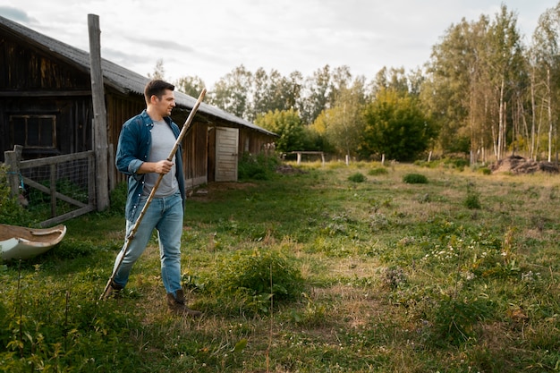 Foto gratuita pastore che cammina sulla vista laterale del campo