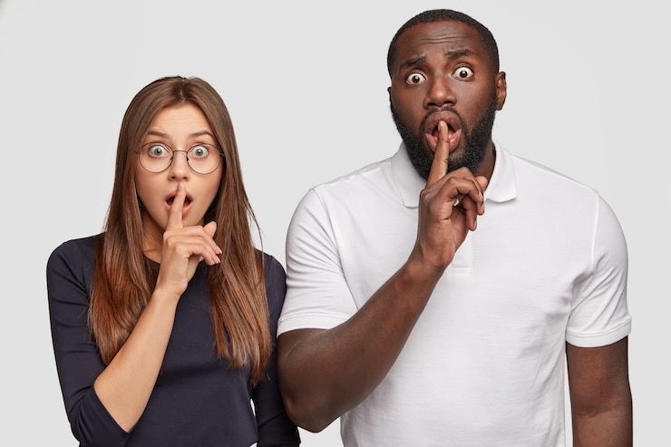 Free Photo shh. interracial couple doing silence gesture