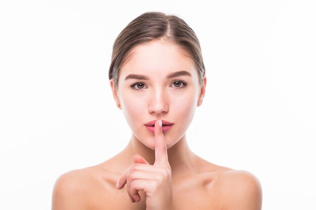 静けさ 唇に人差し指を保持している白人女性のヘッドショット 黒い髪の女性受付係は 白い壁にshhと言って静かに保つようにお願いします 沈黙のコンセプト 無料の写真