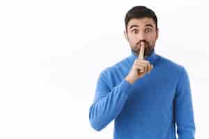 Free photo shhh keep your voice down. enthusiastic handsome caucasian guy prepare surprise, asking be quiet, shush  with index finger pressed to lips, need silence, standing white wall