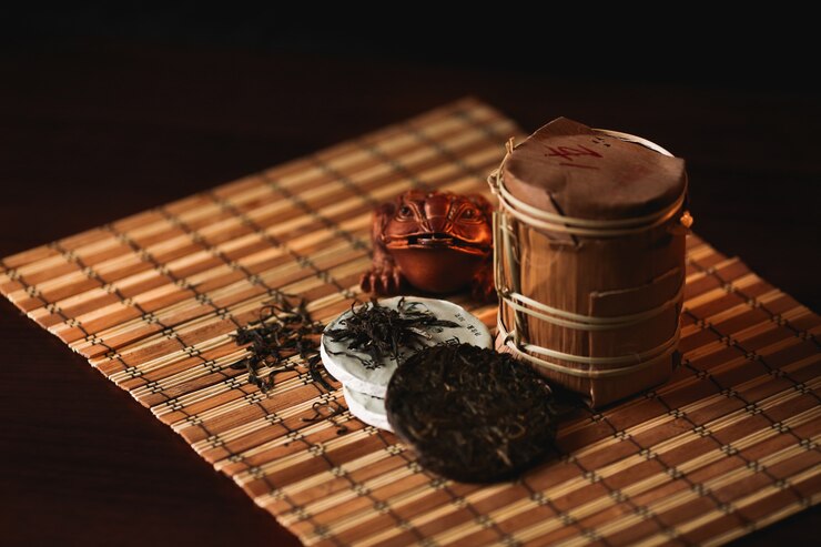 어두운 배경에 부처님 동상 Сhinese puer 차. 전통 중국 차.