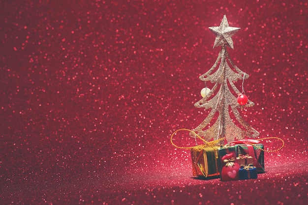 Shiny background with a decorative christmas tree with gifts